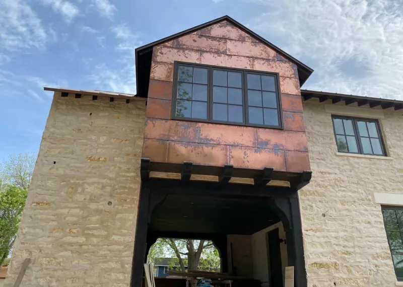 Copper metal panel facade on a stone building for Skylight Installation in Mount Zion